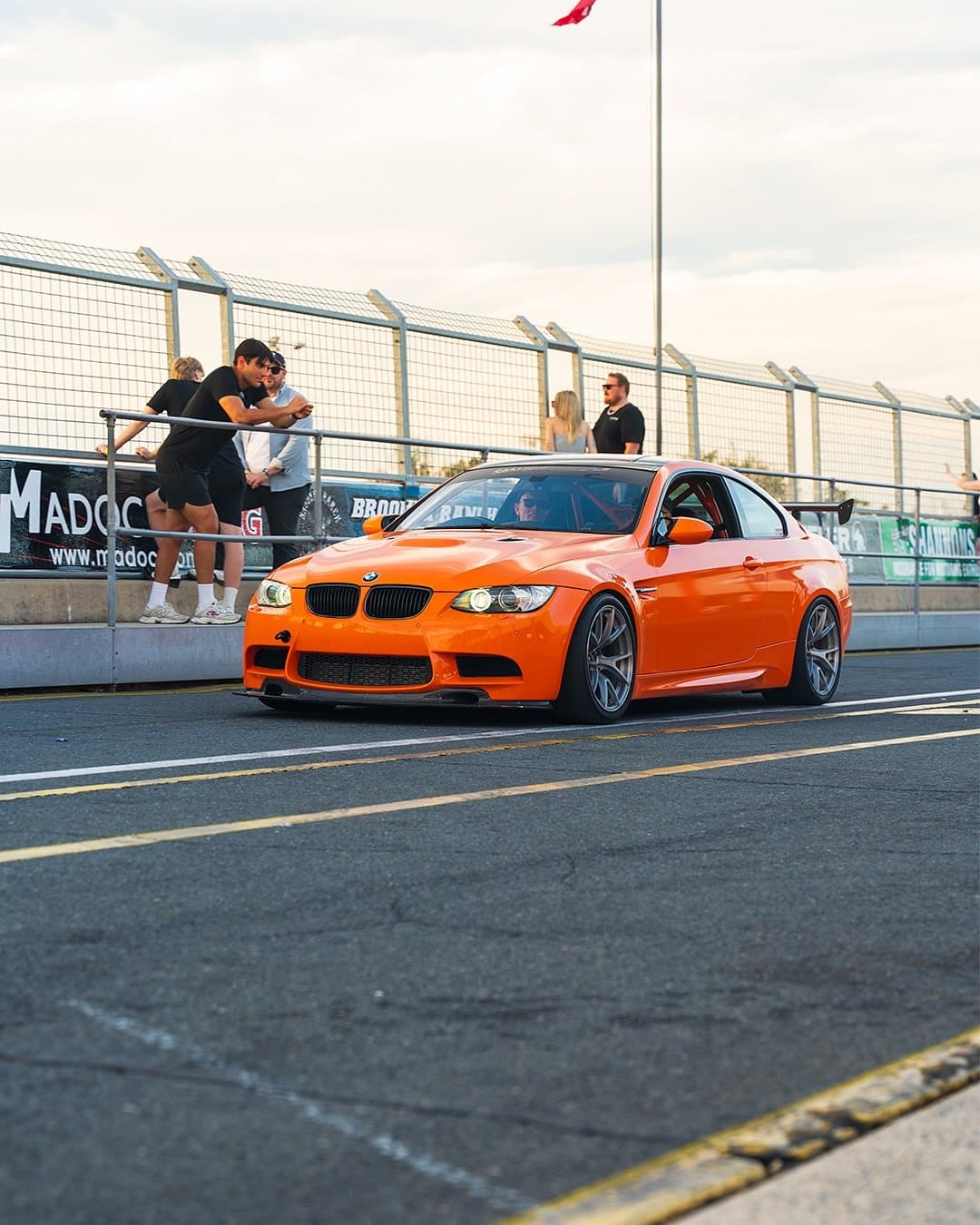Orange BMW E92 M3 on track at golden hour