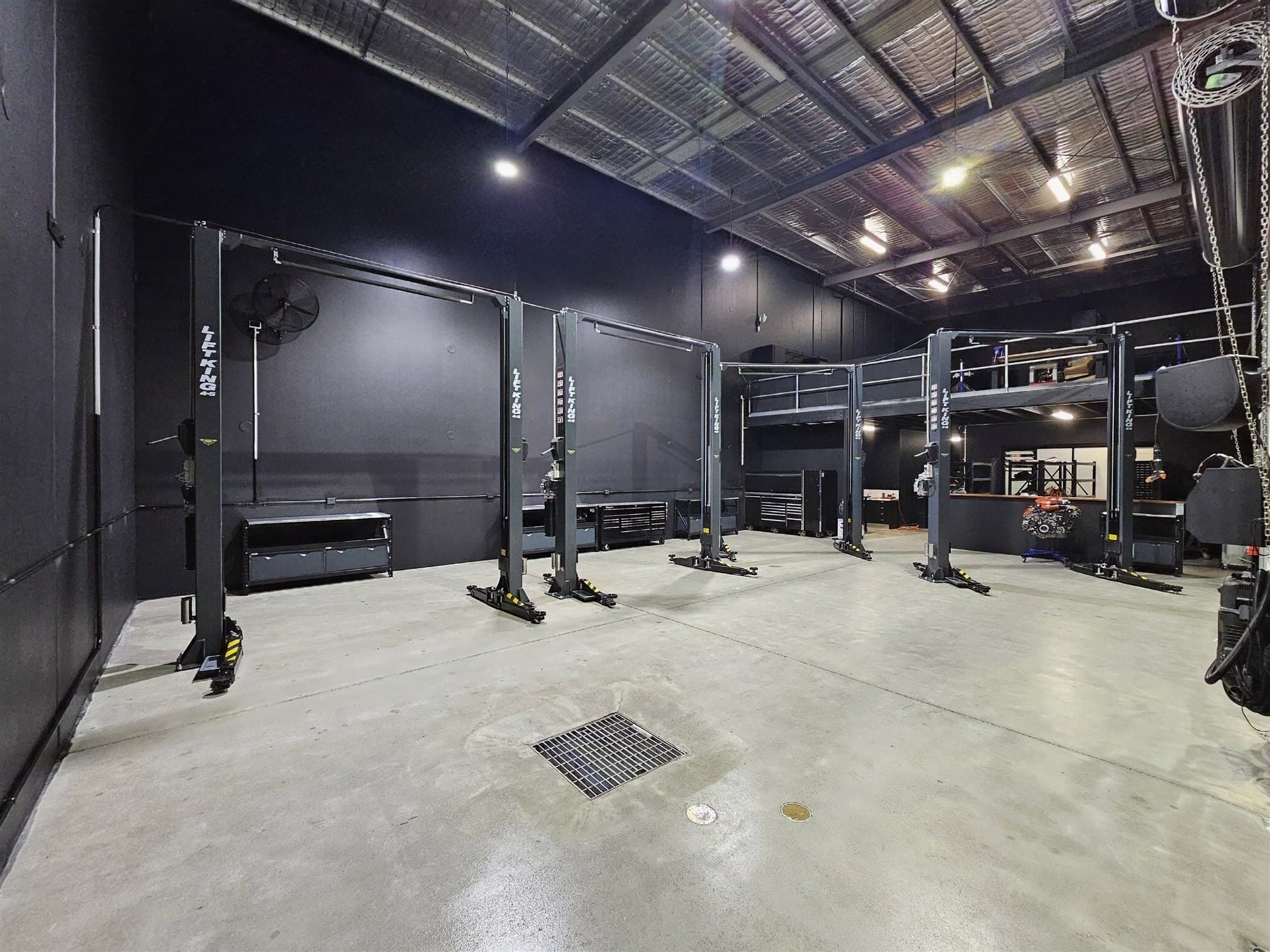 Inside the Emporium Performance workshop, showing the full bay of lifts and mezzanine