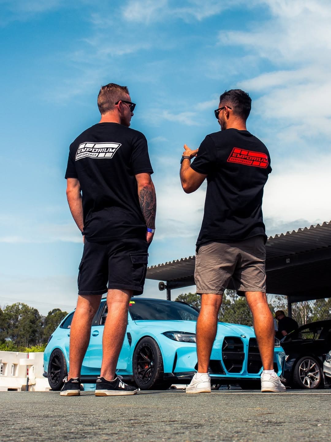 Emporium Performance team members in front of a BMW M3 Touring at a car show